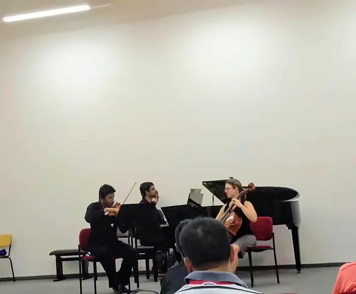 A piano trio with violin and cello at a students’ concert