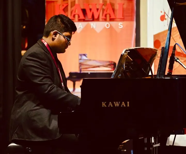 A student playing the Kawai grand at Confluence 2025